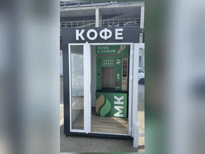 Внутри установлена кофейня — гость заходит и берёт напиток
